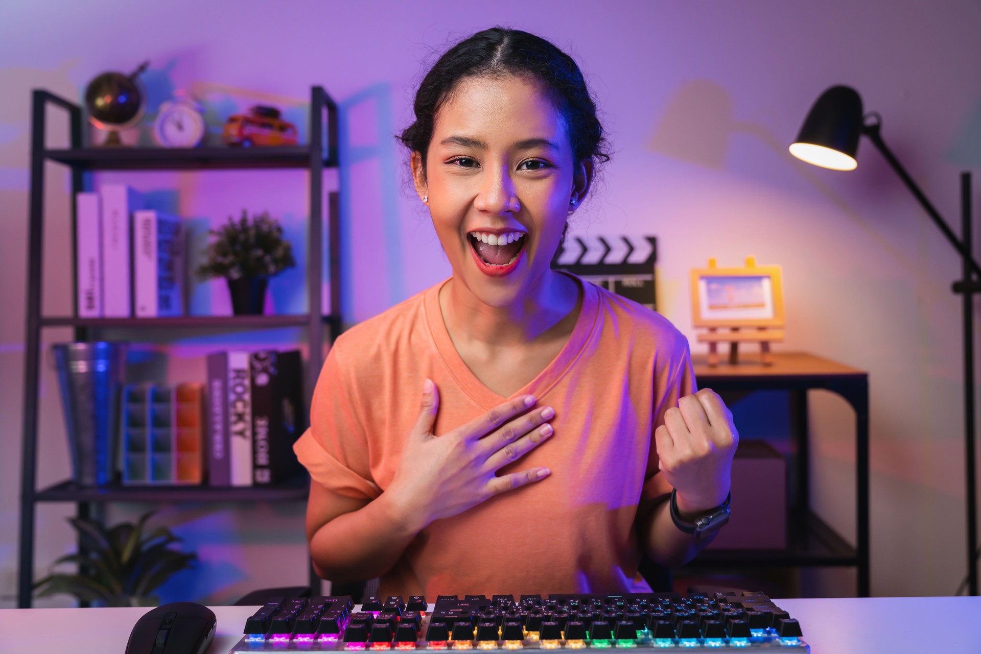 Young Asian woman gamer open mouth with emotional excited and shocked with wearing headset winning the game, celebrating victory expressing success.